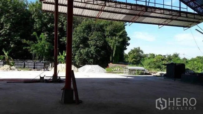 工厂 出售在Phanat Nikhom, Chon Buri - 开放式雨棚仓库空间，可眺望院内与绿树。