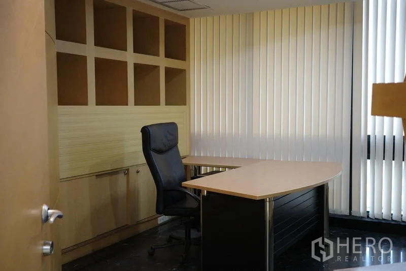 Office Space for rent in Bang Na, Bangkok - Executive office with an L-shaped desk, high-back chair and built-in shelving.