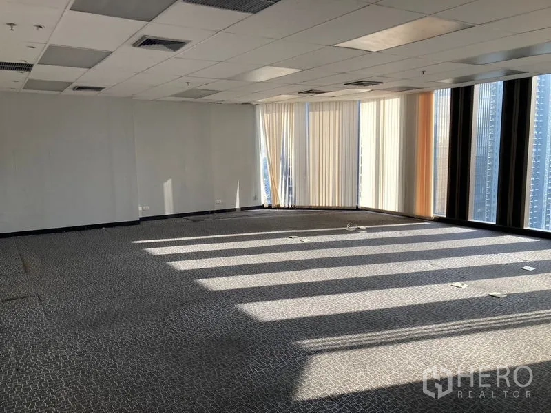 Office Space for rent - Spacious corner office with carpeted floors, drop ceiling and floor-to-ceiling windows with vertical blinds and city views.