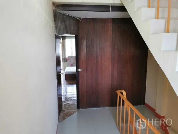 Shophouse for rent in Suan Luang, Bangkok - Landing with wood panel partition and doorway leading to bedroom.