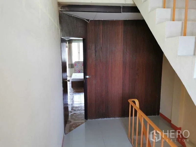 Shophouse for rent in Suan Luang, Bangkok - Landing with wood panel partition and doorway leading to bedroom.