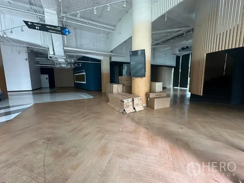 Office Space for rent - Spacious lobby area with wood floors, exposed white ceiling, round columns and boxes ready for fit-out.
