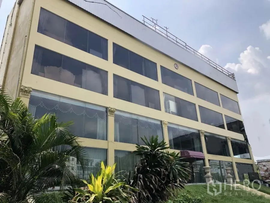 Home Office for rent or sale in Huai Khwang, Bangkok - Multi-storey home office with full-height glass facade and landscaped frontage in Huai Khwang, Bangkok.