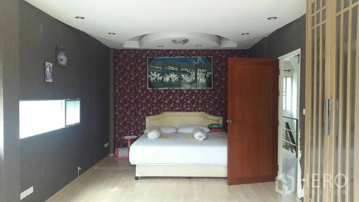 Townhouse for rent in Suan Luang, Bangkok - Master bedroom with accent wall, feature ceiling and door to the en-suite.