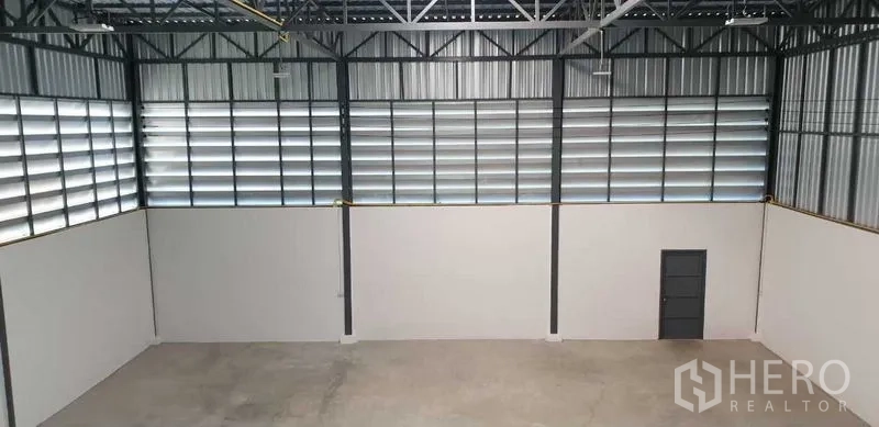 工厂 出租在Lam Luk Ka, Pathum Thani - 宽阔仓库墙面，横向百叶窗与钢结构框架