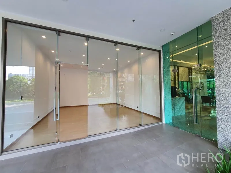 Retail Space for rent in Watthana, Bangkok - Wide glass shopfront beside the lobby of a contemporary condominium building.