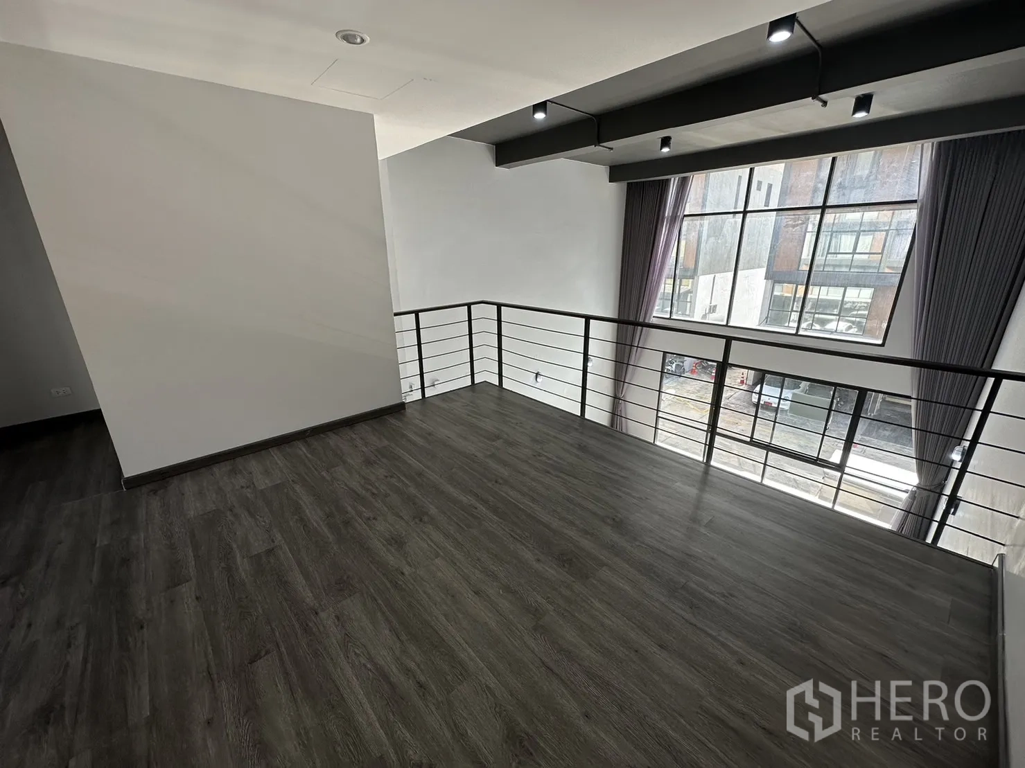 Home Office for rent or sale in Suan Luang, Bangkok - Mezzanine viewpoint over the street through big picture windows with grey curtains.
