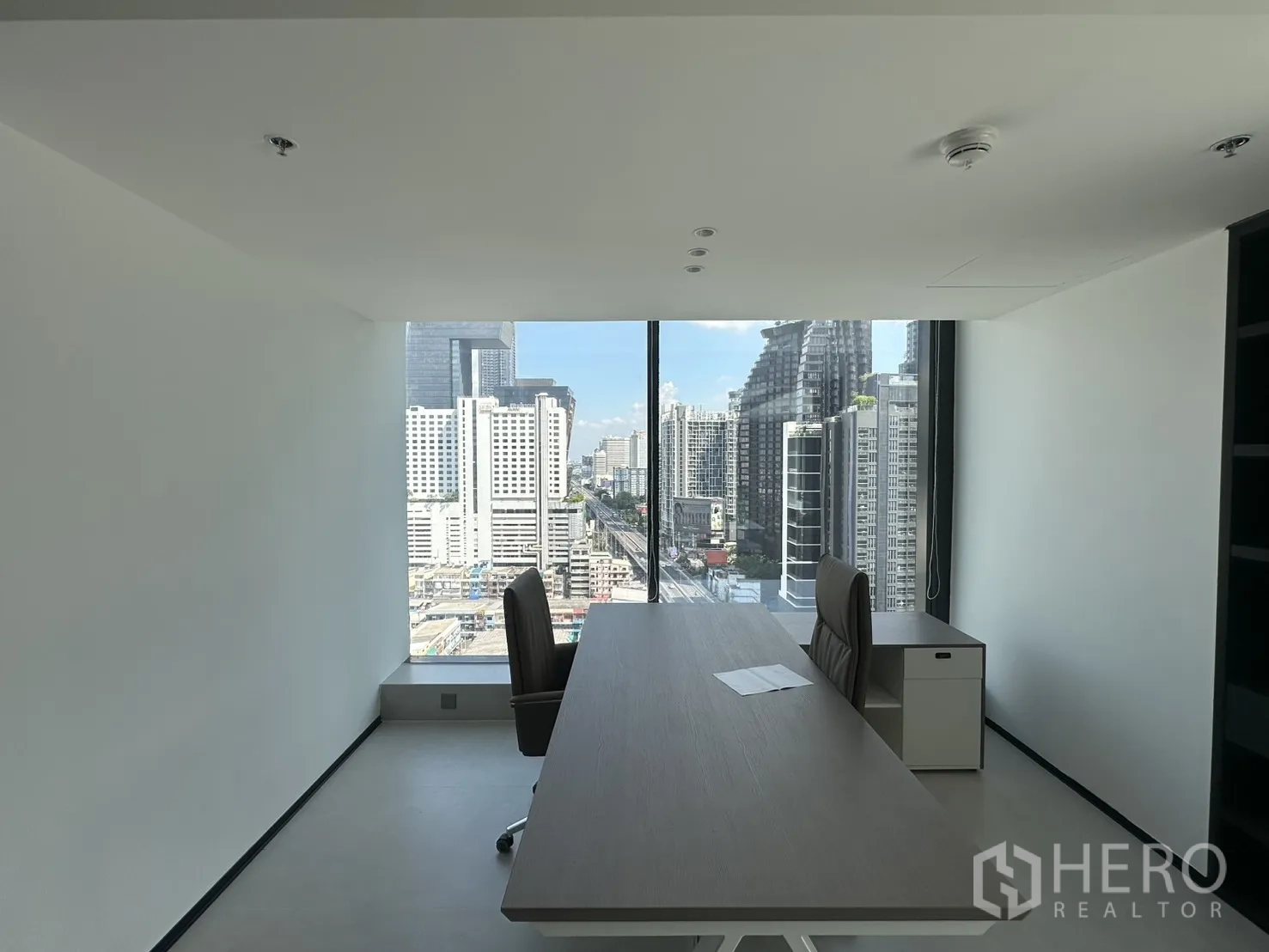 Office Space for rent in Din Daeng, Bangkok - Private office with a desk for two and skyline views through a large window.