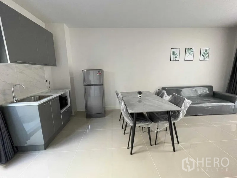 Townhouse for rent in Prawet, Bangkok - Spacious open-plan living with kitchenette, dining set and sofa.