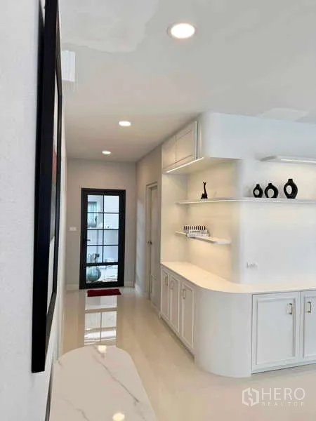 Detached House for rent or sale in Bang Phli, Samut Prakan - Hallway featuring curved built-in cabinetry, floating shelves and a glass back door.