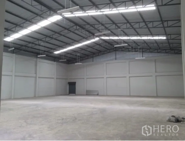 Warehouse for rent in Bang Phli, Samut Prakan - Spacious warehouse hall with steel truss roof, skylights, and concrete floor.