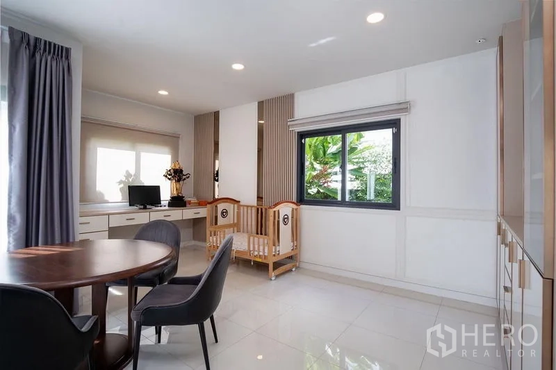 Detached House for rent in Bang Phli, Samut Prakan - Multipurpose area with round dining table, work desk and crib next to a window.