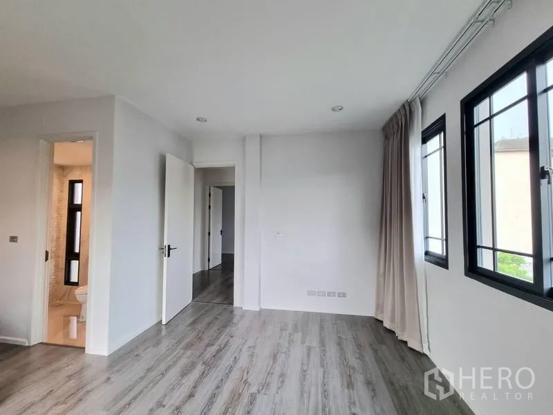 Detached House for rent - Bedroom with en-suite access, multiple windows, and wood flooring.