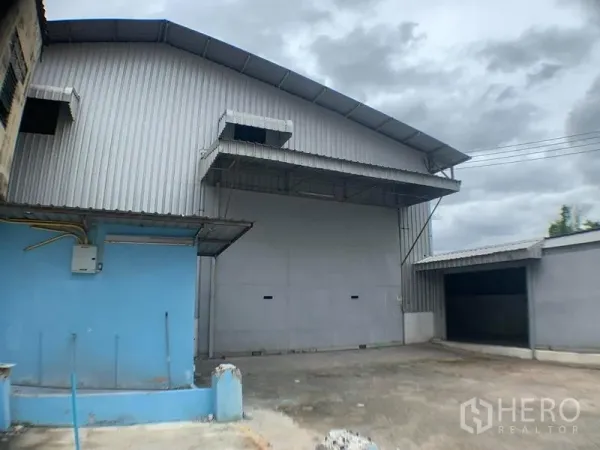 货栈 出租在Lak Si, Bangkok - 金属板外墙的仓库外观，带有雨棚装卸区和硬化场地
