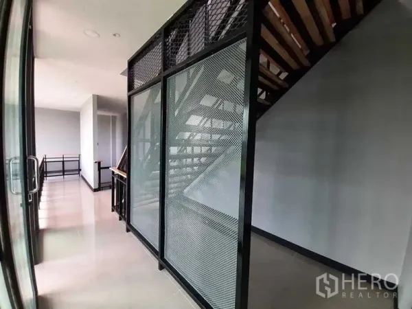 Factory for rent or sale - Industrial-style staircase with metal mesh enclosure and glossy tiled floor in the office area.