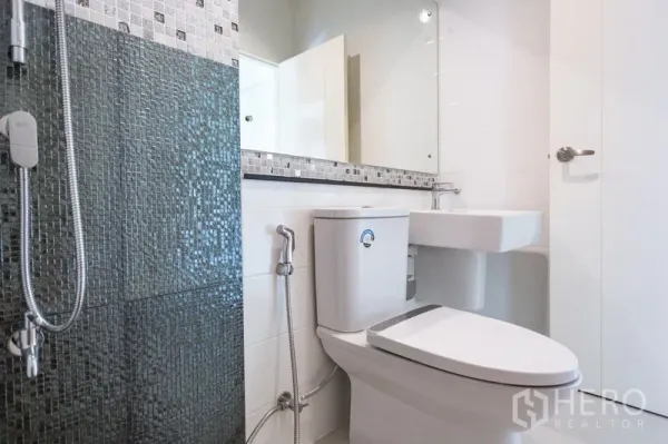 Townhouse for rent in Bang Phli, Samut Prakan - Contemporary bathroom featuring a mosaic-tile shower, wide mirror and white sanitary ware.