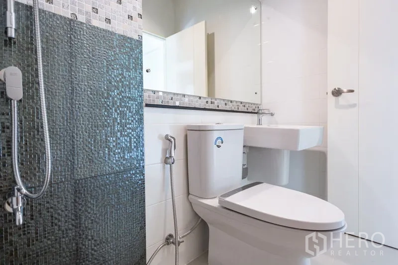 Townhouse for rent in Bang Phli, Samut Prakan - Contemporary bathroom featuring a mosaic-tile shower, wide mirror and white sanitary ware.