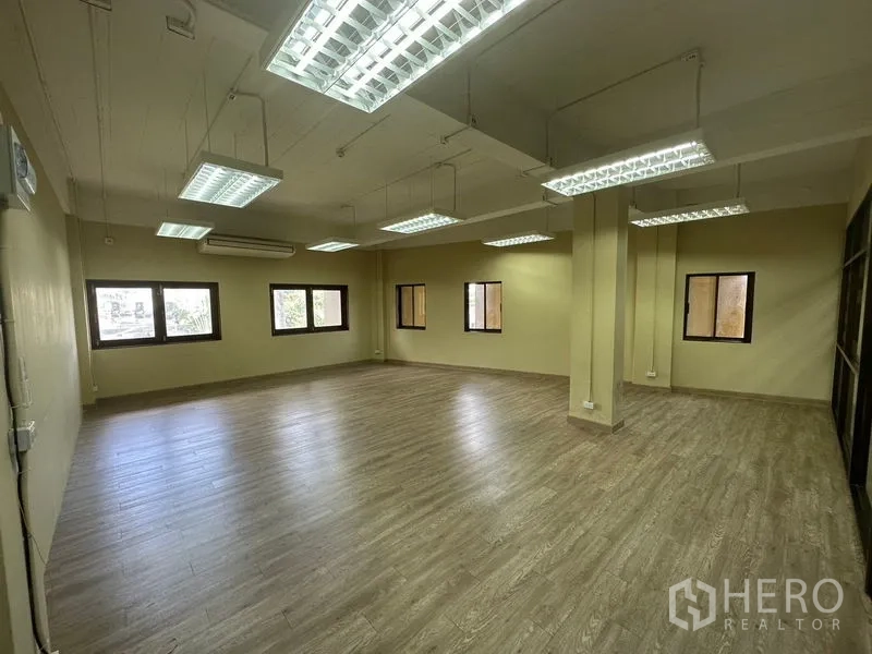 Office Space for rent in Chatuchak, Bangkok - Spacious corner office area with wood flooring, support columns, air conditioner and several windows for natural light.