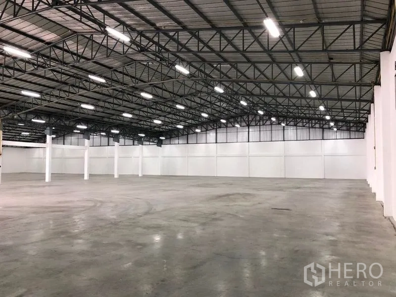 货栈 出租在Pak Kret, Nonthaburi - 大型无柱空间，金属保温屋顶与均匀分布的照明灯具。