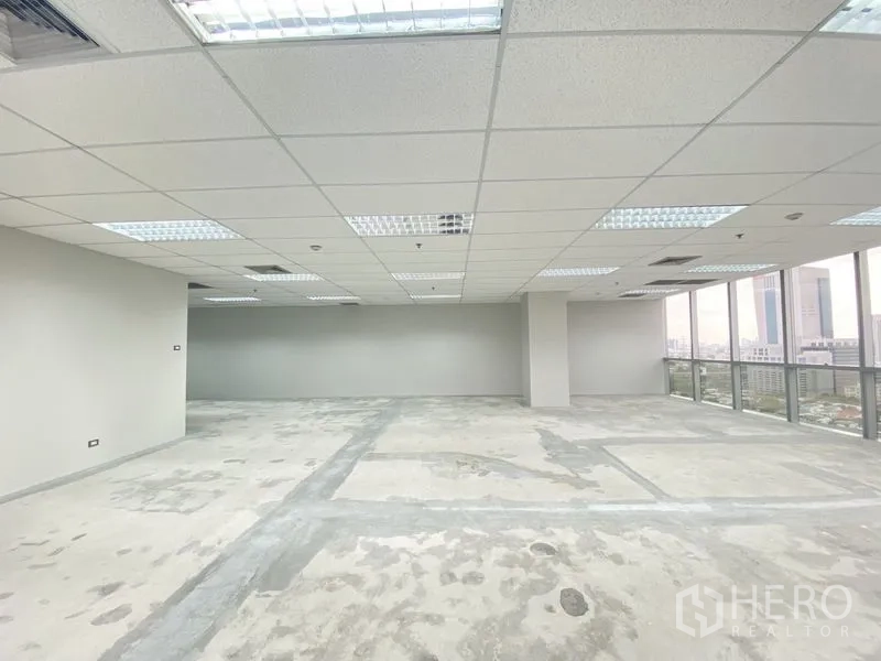 Office Space for rent in Chatuchak, Bangkok - Unfurnished office area with large windows, neutral walls, acoustic ceiling and abundant natural daylight.