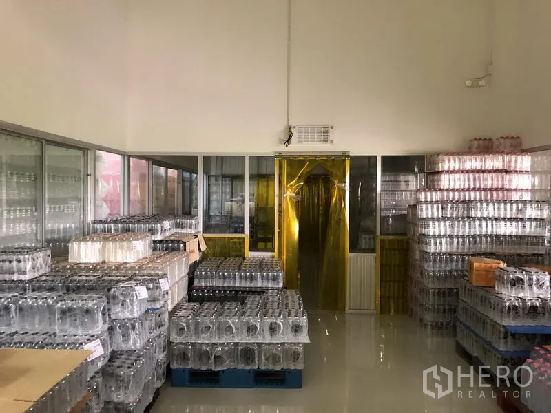 Factory for rent or sale in Wang Noi, Phra Nakhon Si Ayutthaya - Clean storage area with yellow strip curtains and neatly stacked inventory.
