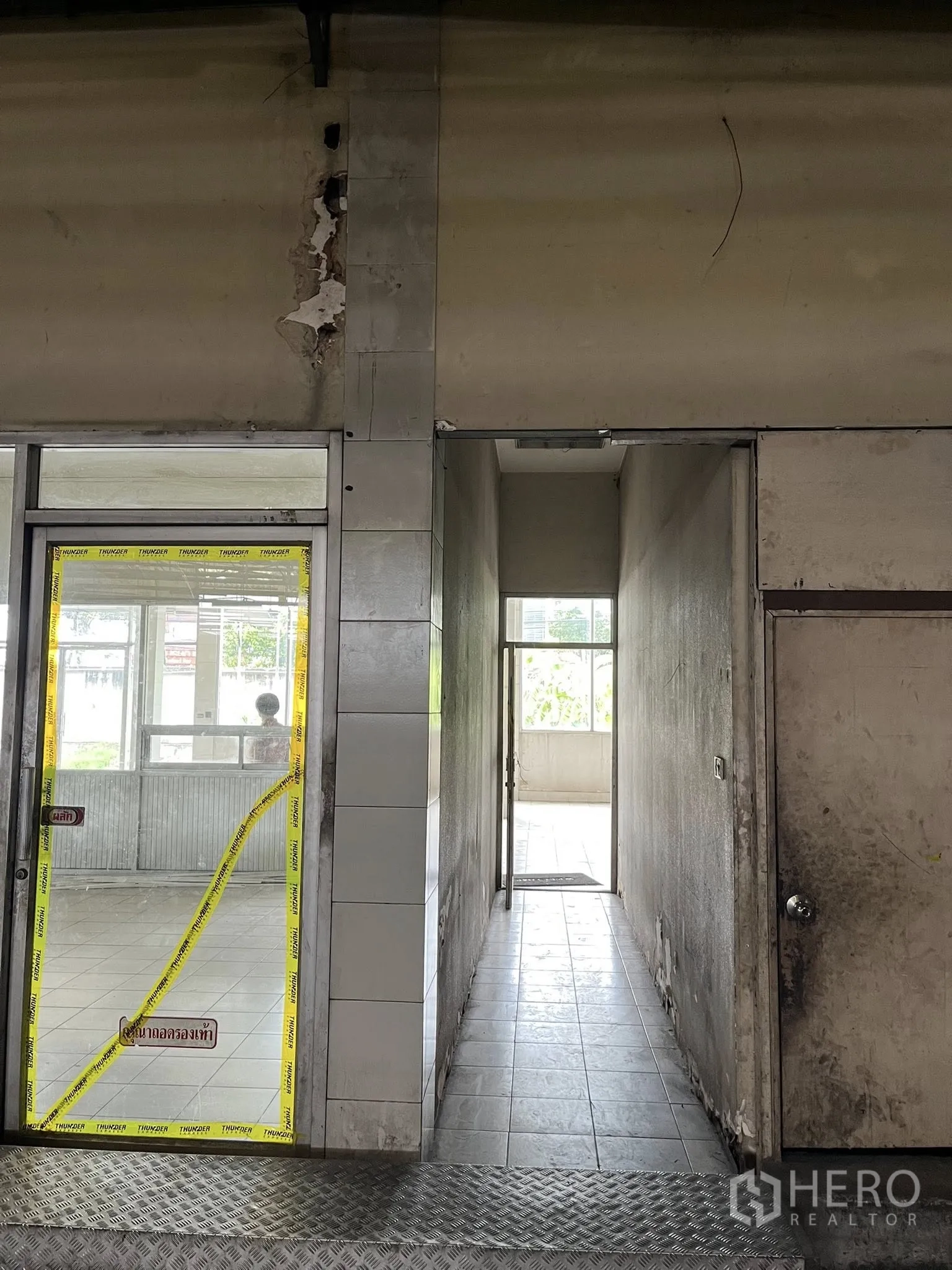 Factory for rent in Phra Pradaeng, Samut Prakan - Tiled corridor connecting the warehouse to office areas with side doors.