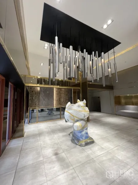 Shophouse for rent in Phra Khanong, Bangkok - Open showroom with dramatic pendant chandelier, tiled flooring and full glass frontage.