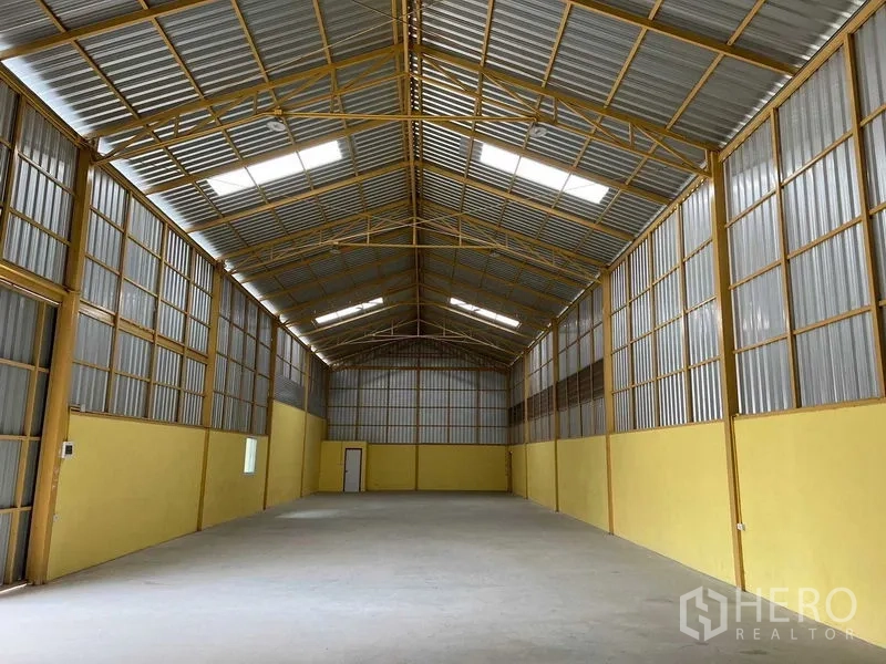 Warehouse for rent in Lat Krabang, Bangkok - Spacious warehouse interior with high gabled metal roof, skylights, and clear‑span concrete floor.