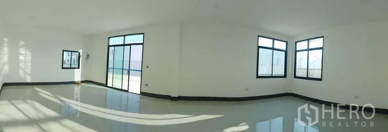 Factory for rent or sale in Sai Noi, Nonthaburi - Large office space with sliding glass doors and full-height windows facing the yard.