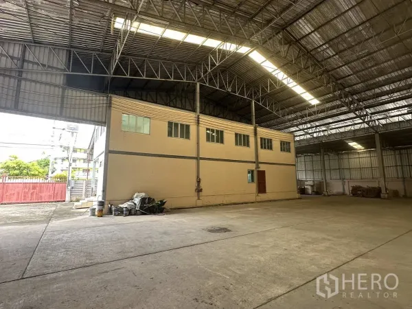 Factory for rent in Pathum Thani - Internal two-storey office block beneath the tall warehouse roof with broad access opening to the yard.