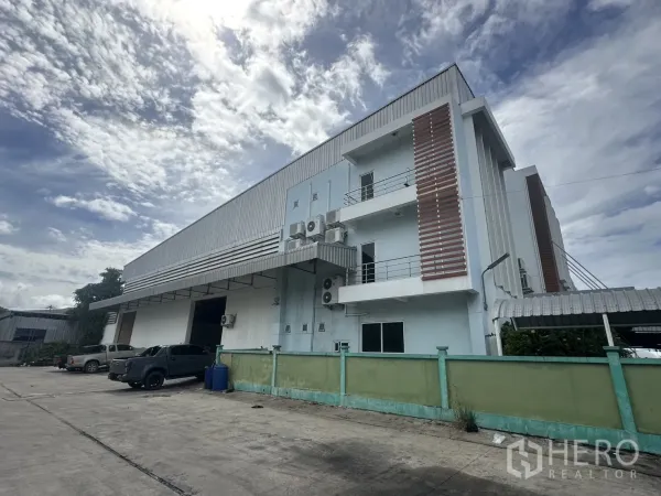 Factory for rent - Side elevation showing balconies, air-conditioning units, and warehouse wall.