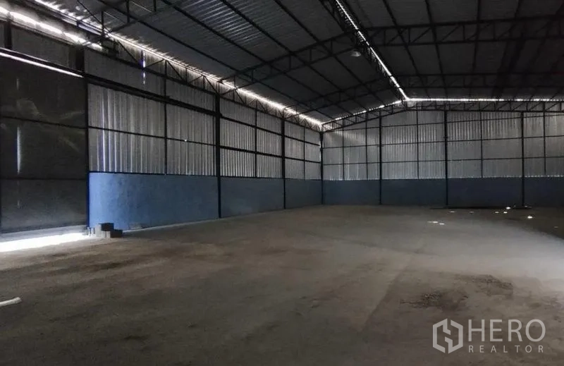 货栈 出租在Si Racha, Chon Buri - 钢结构仓库内部，高挑屋顶与混凝土地面