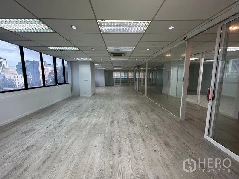 Office Space for rent in Din Daeng, Bangkok - Expansive open office with wall-to-wall windows and glass-walled rooms.