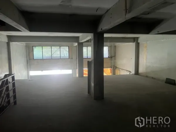 Shophouse for rent in Watthana, Bangkok - Mezzanine level overlooking the lower floor with beams, pillars, and windows.