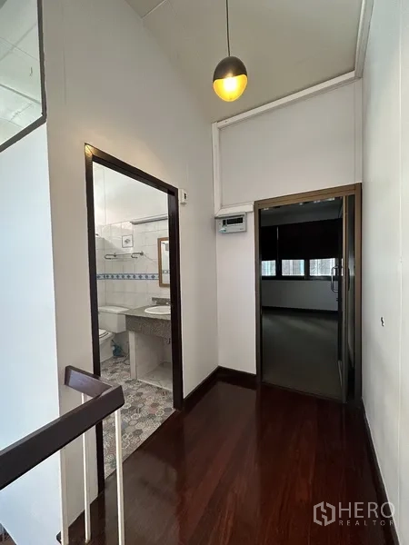 Detached House for rent in Watthana, Bangkok - Landing with bathroom access and pendant light next to doorway to a bedroom.