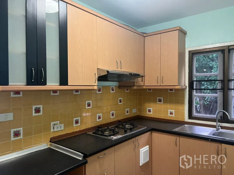 Detached House for rent in Bang Na, Bangkok - Kitchen close-up showing gas hob, hood and upper cabinets