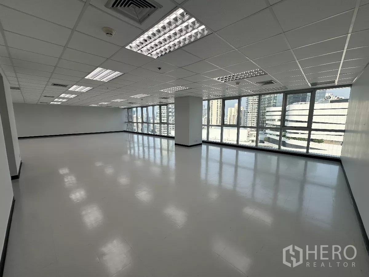 Office Space for rent in Watthana, Bangkok - High-floor open-plan office with full glass windows and Bangkok skyline views under bright grid ceiling lights.