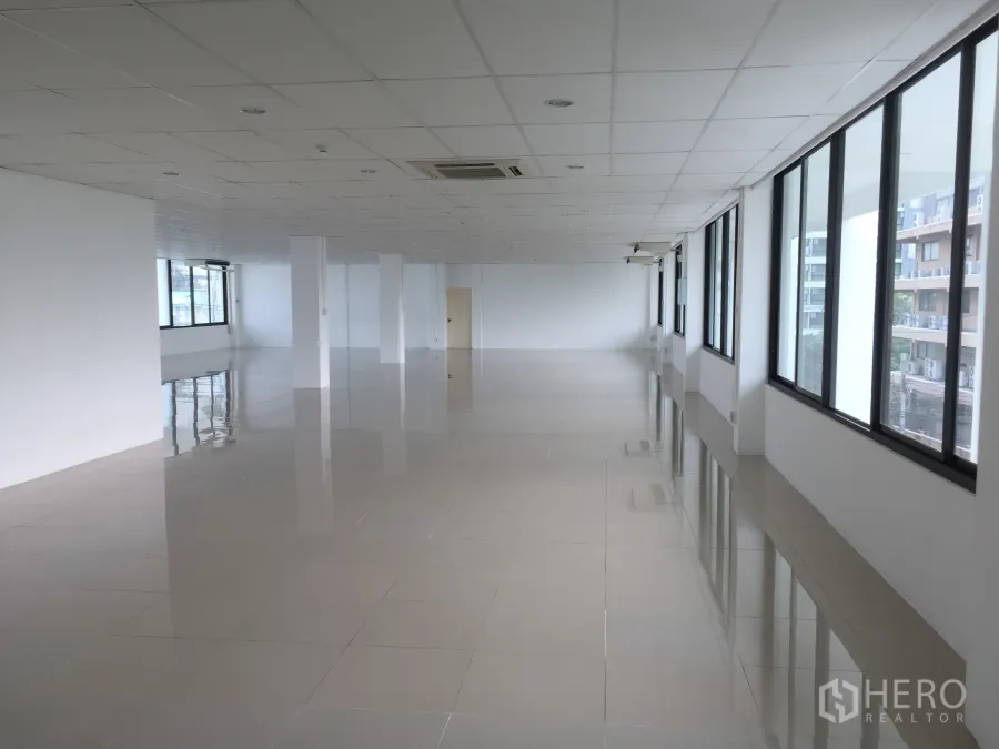 Office Space for rent in Khlong Toei, Bangkok - Spacious 296 sqm open-plan office floor with tiled flooring, drop ceiling, columns and wide windows bringing abundant natural light.