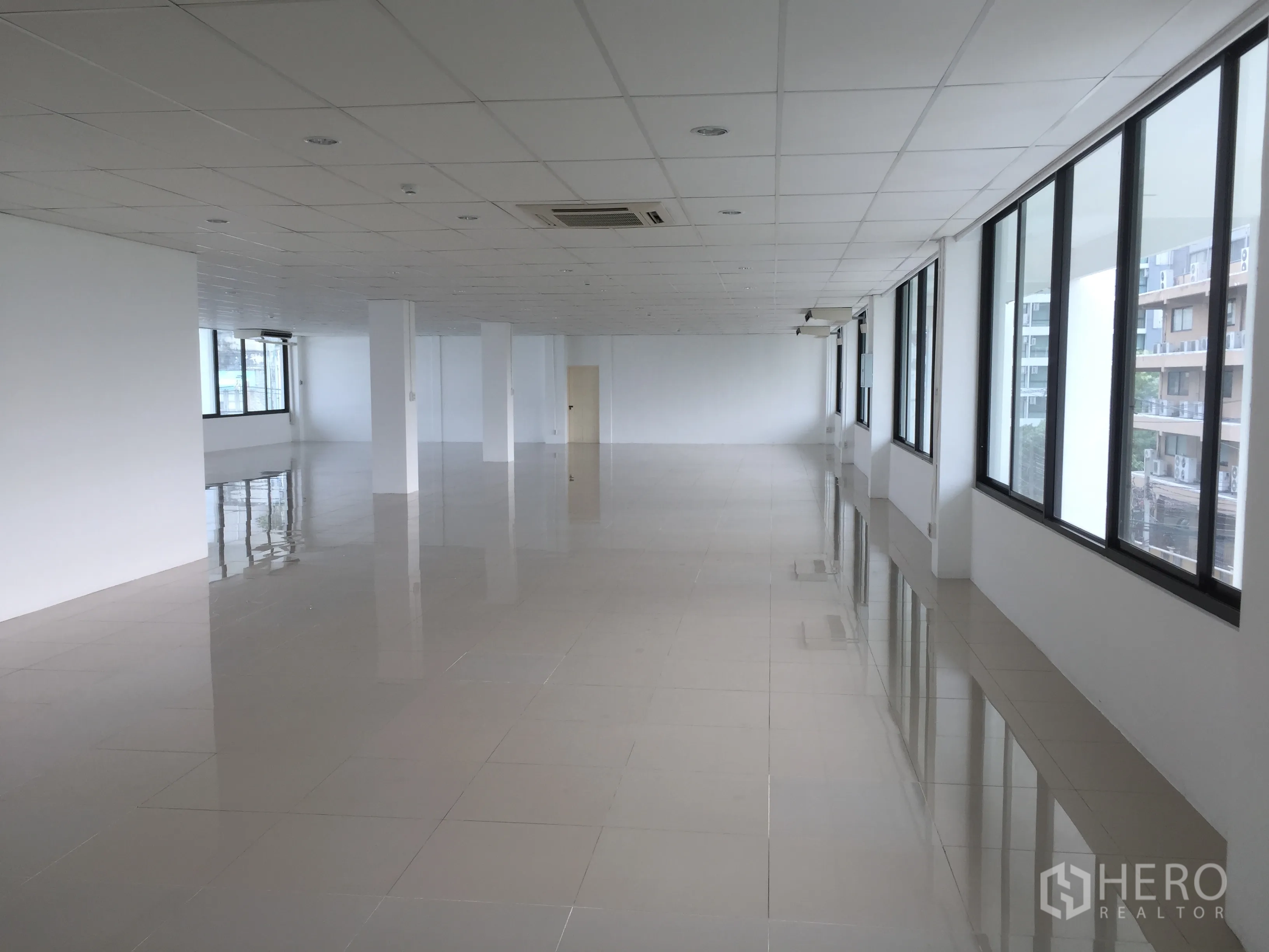 Office Space for rent in Khlong Toei, Bangkok - Spacious 296 sqm open-plan office floor with tiled flooring, drop ceiling, columns and wide windows bringing abundant natural light.