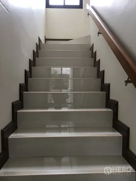 Home Office for rent in Bang Rak, Bangkok - Wide tiled staircase with wooden handrail and natural light from an upper window.