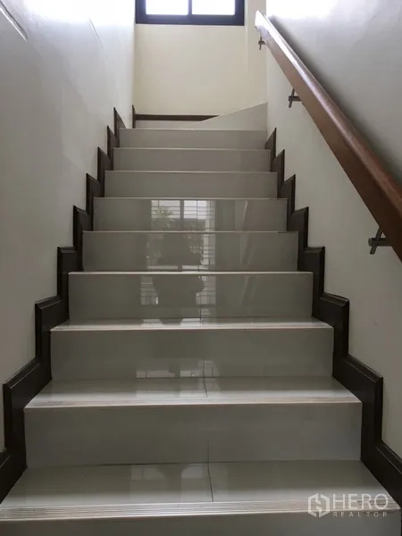Home Office for rent in Bang Rak, Bangkok - Wide tiled staircase with wooden handrail and natural light from an upper window.