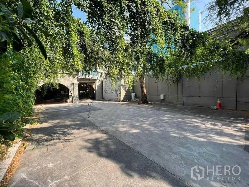 Retail Space for rent in Phaya Thai, Bangkok - Courtyard view toward the arched facade under cascading greenery.