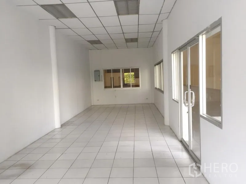Factory for rent in Khlong Luang, Pathum Thani - Clean tiled office room with drop ceiling, glass doors and windows inside the factory.