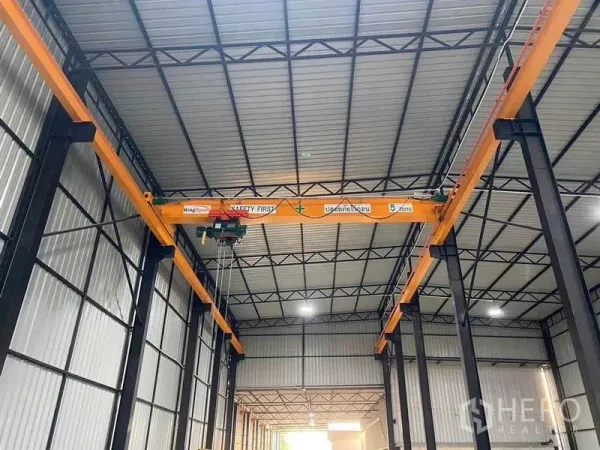 Warehouse for sale in Mueang Samut Prakan, Samut Prakan - High-bay warehouse interior with a 5-ton overhead crane and steel truss roof.