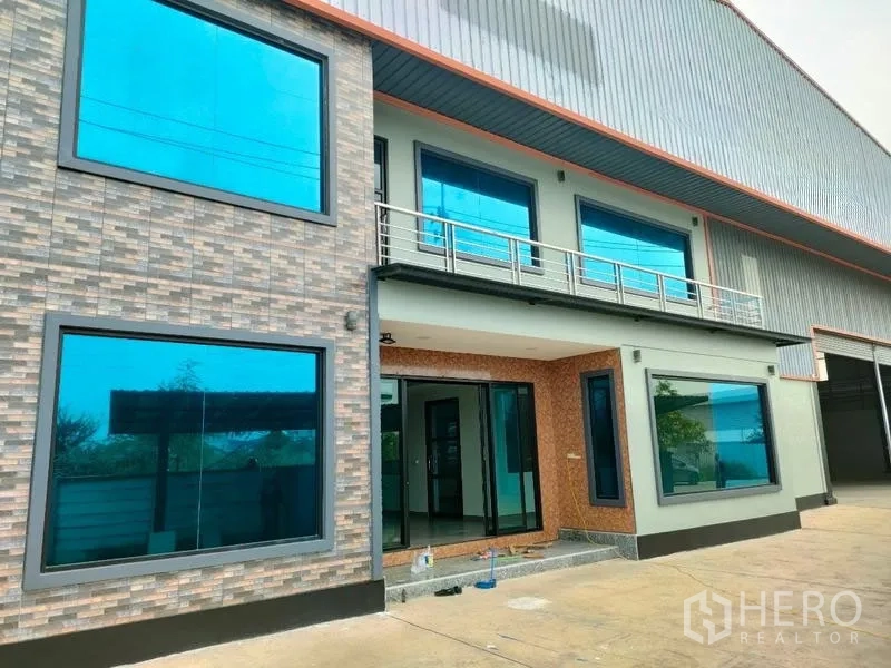 Factory for rent in Ban Phaeo, Samut Sakhon - Modern factory facade with large blue-tinted windows and roller doors in Samut Sakhon.