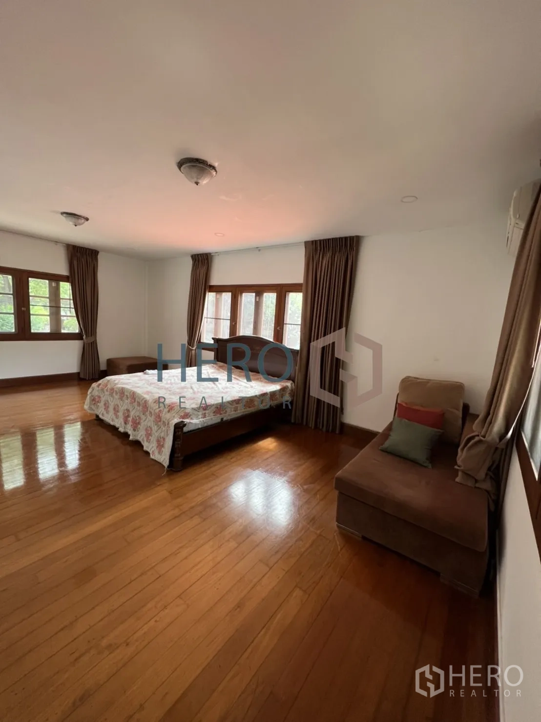 Detached House for rent in Watthana, Bangkok - Large bedroom with bed, corner seating and natural light.