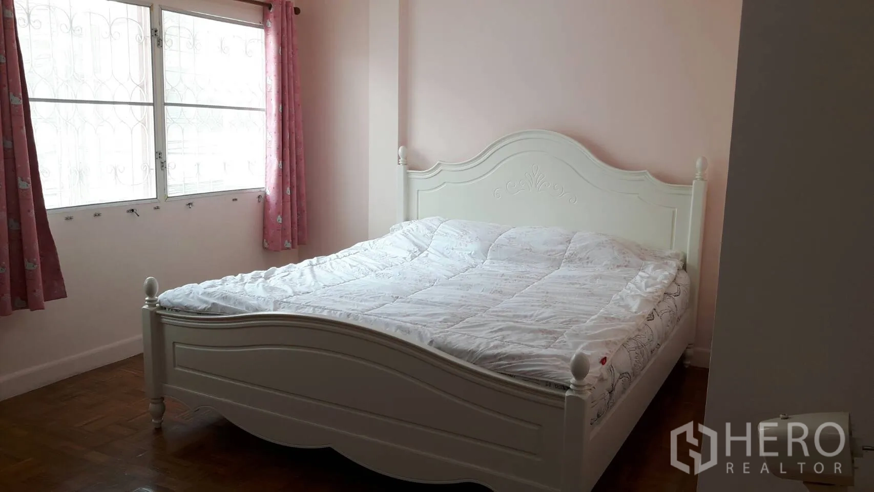 Townhouse for rent in Khlong Toei, Bangkok - Bright bedroom with a white queen bed, parquet floor, and curtained window.