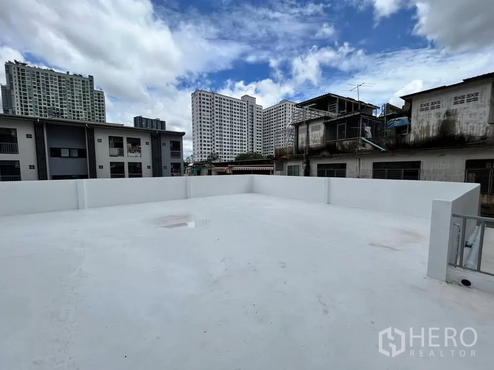 Detached House for rent in Suan Luang, Bangkok - White rooftop terrace with city condo views under blue sky.