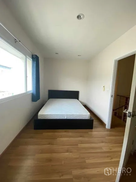 Townhouse for rent in Suan Luang, Bangkok - Secondary bedroom with double bed, large window and wood flooring.