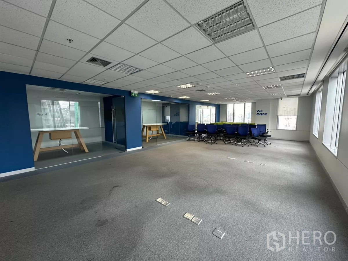 Office Space for rent in Watthana, Bangkok - Open floor plate with glass rooms and a conference area marked 'We care'.